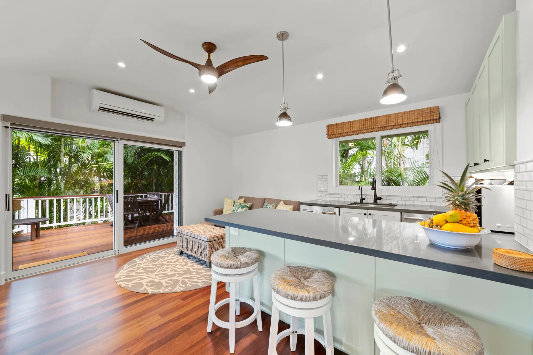 Una cocina luminosa con una isla larga y puertas corredizas de vidrio que dan a un patio.