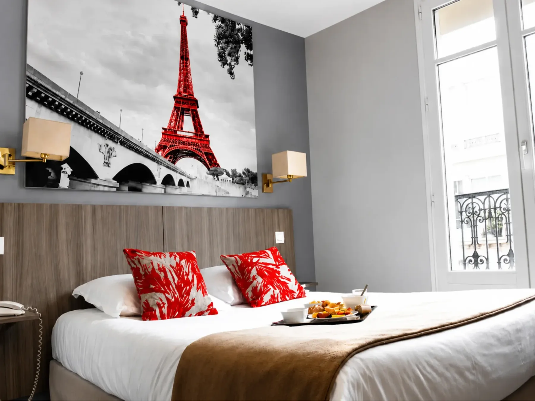 Guest room with red cushions and Paris-themed wall art