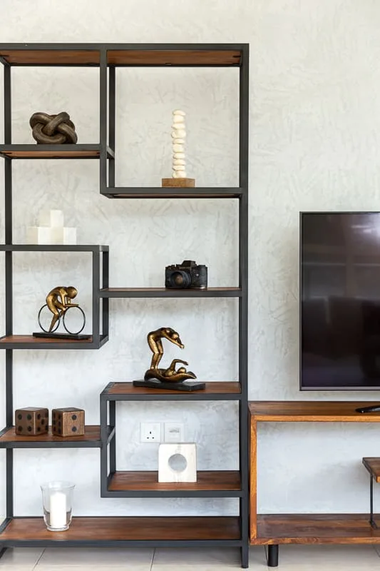 Una estantería de sala muestra objetos decorativos junto a un televisor.