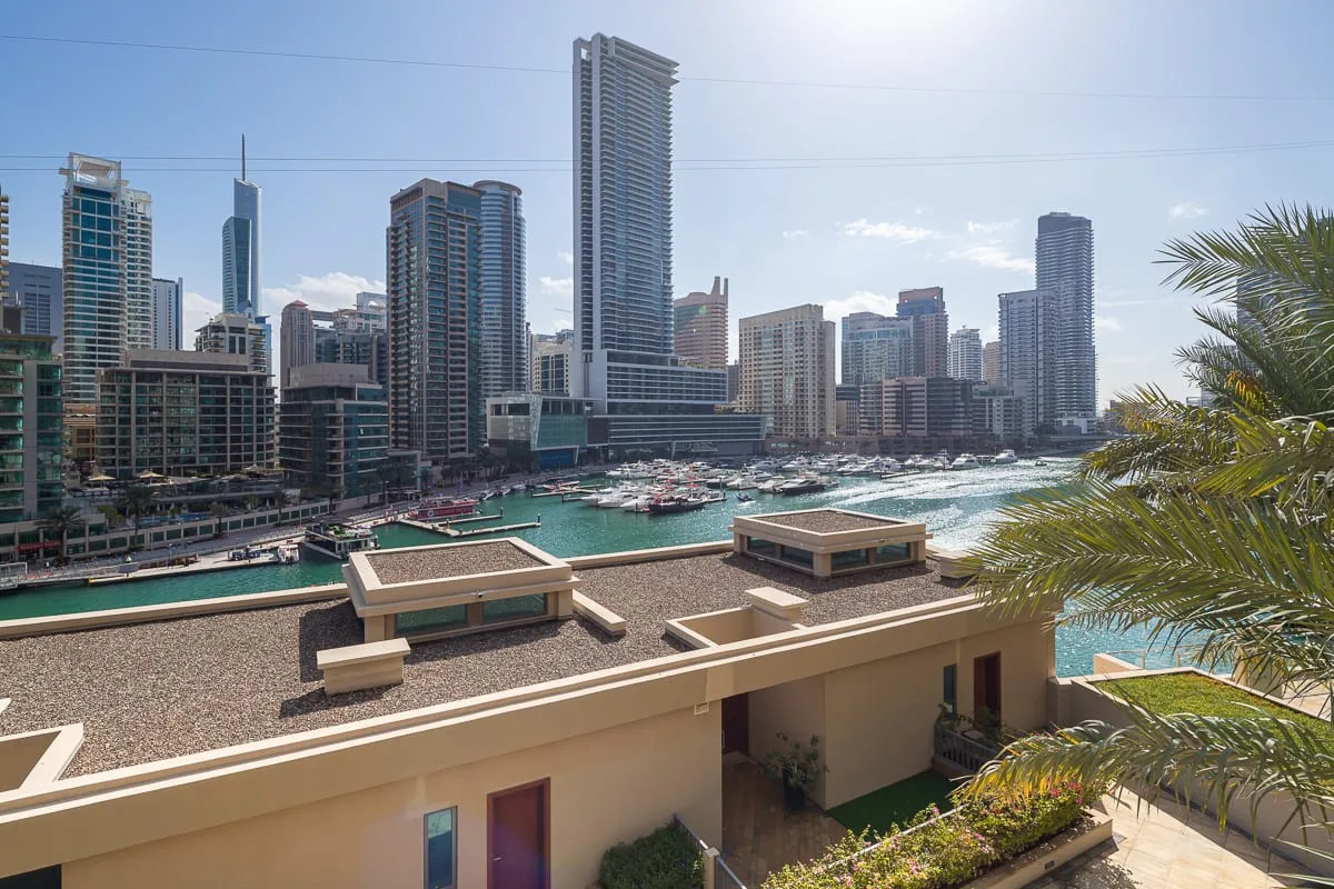 Un horizonte urbano junto al agua domina una marina y aguas turquesas.