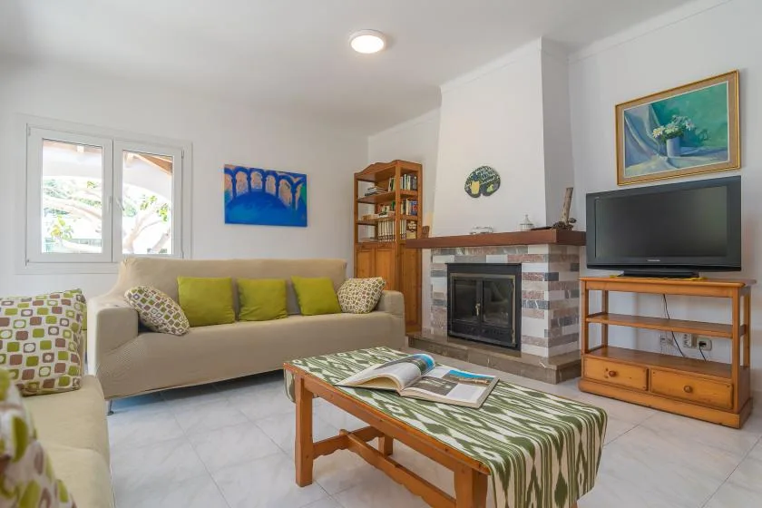 A living room with seating, a fireplace, and a television.