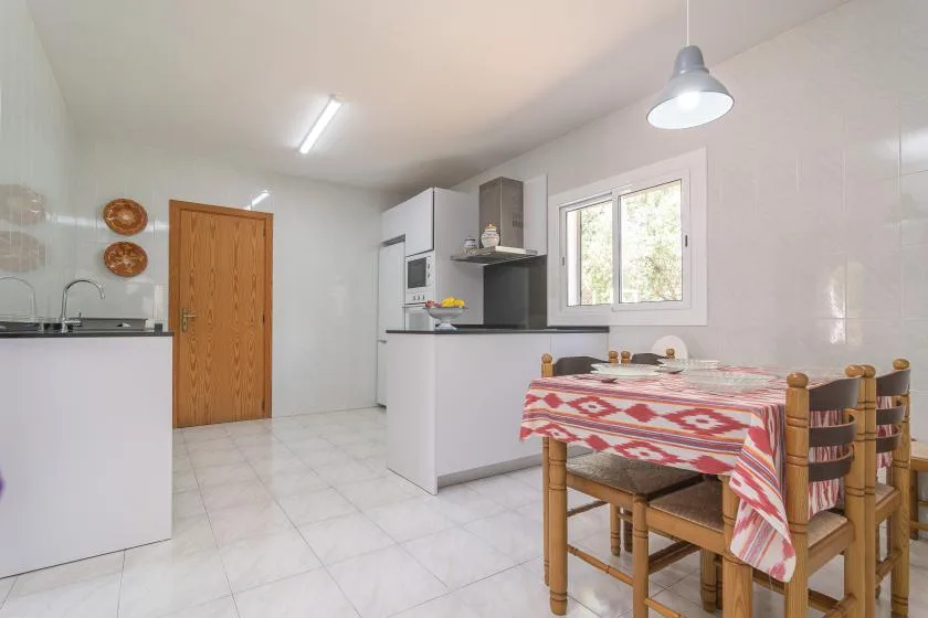 A kitchen and dining area with a table beside the window.