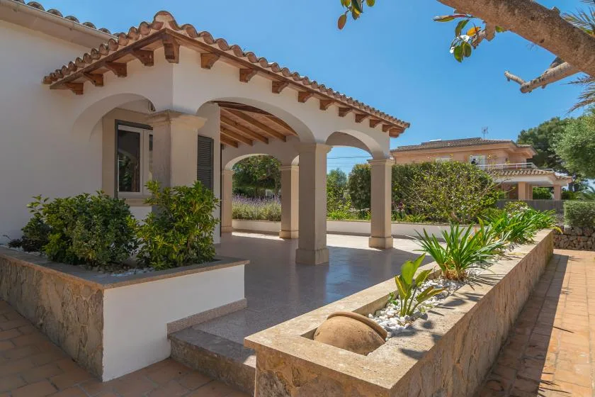A covered outdoor patio with arched openings and a raised planter.