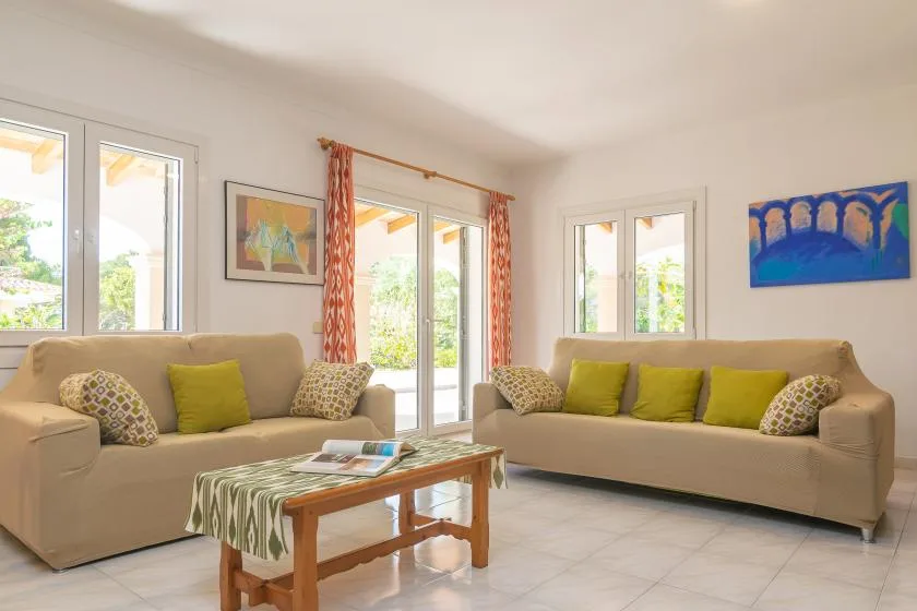 A bright living room with beige seating and a wooden coffee table.