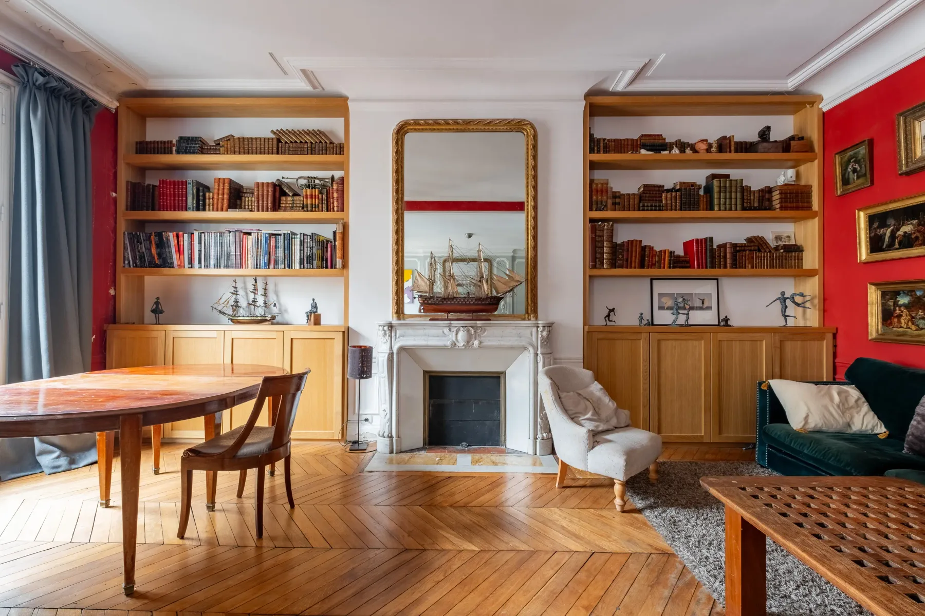 Una sala de estar con estanterías, una chimenea y asientos.