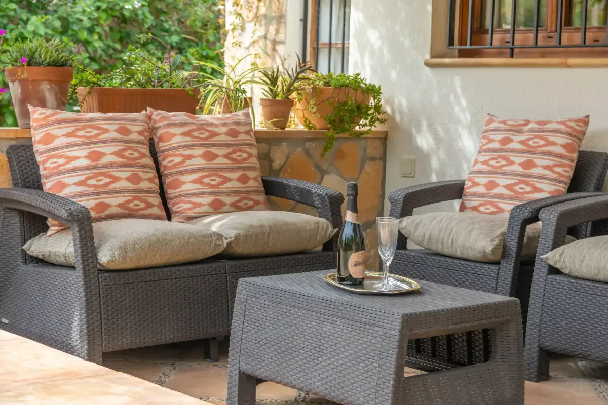 A furnished outdoor patio with cushioned seating and potted plants.