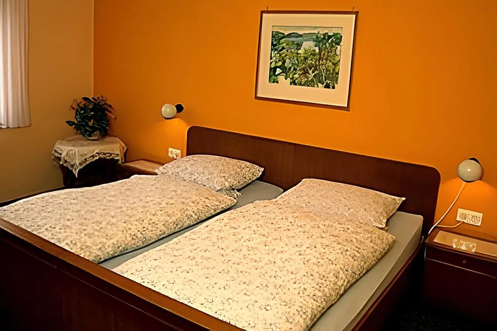 Habitación con cama doble y paredes naranjas