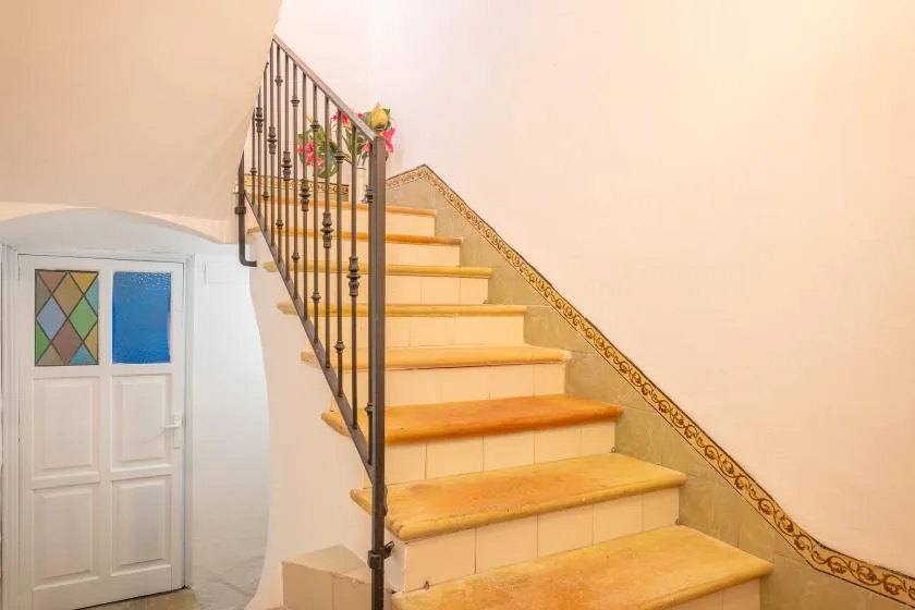 A staircase with wooden steps and a decorative metal railing.