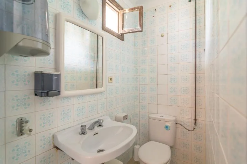 A tiled bathroom with a sink, toilet, and shower.