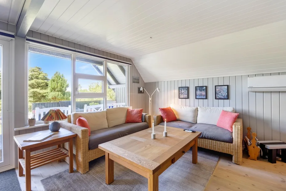 A bright living room with seating arranged around a wooden coffee table.