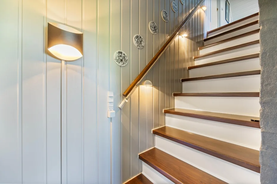 A staircase with wooden steps and a wall-mounted light.