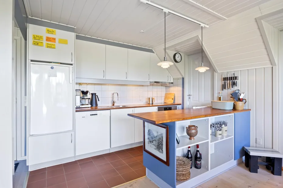 A bright kitchen with white cabinets and a central island.