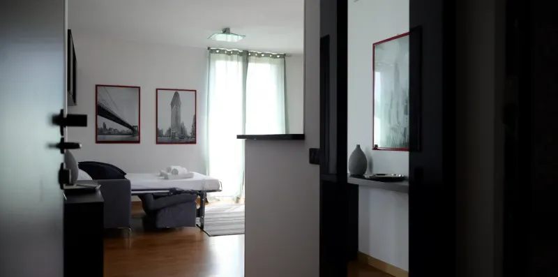Un dormitorio con una cama, asientos junto a ella y cuadros en la pared.