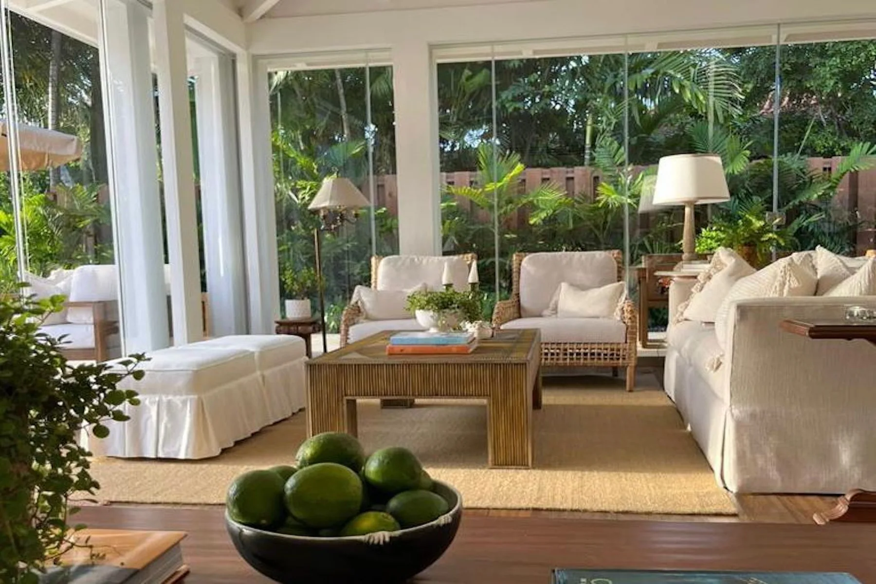 A bright living room with seating around a low wooden table and large windows.
