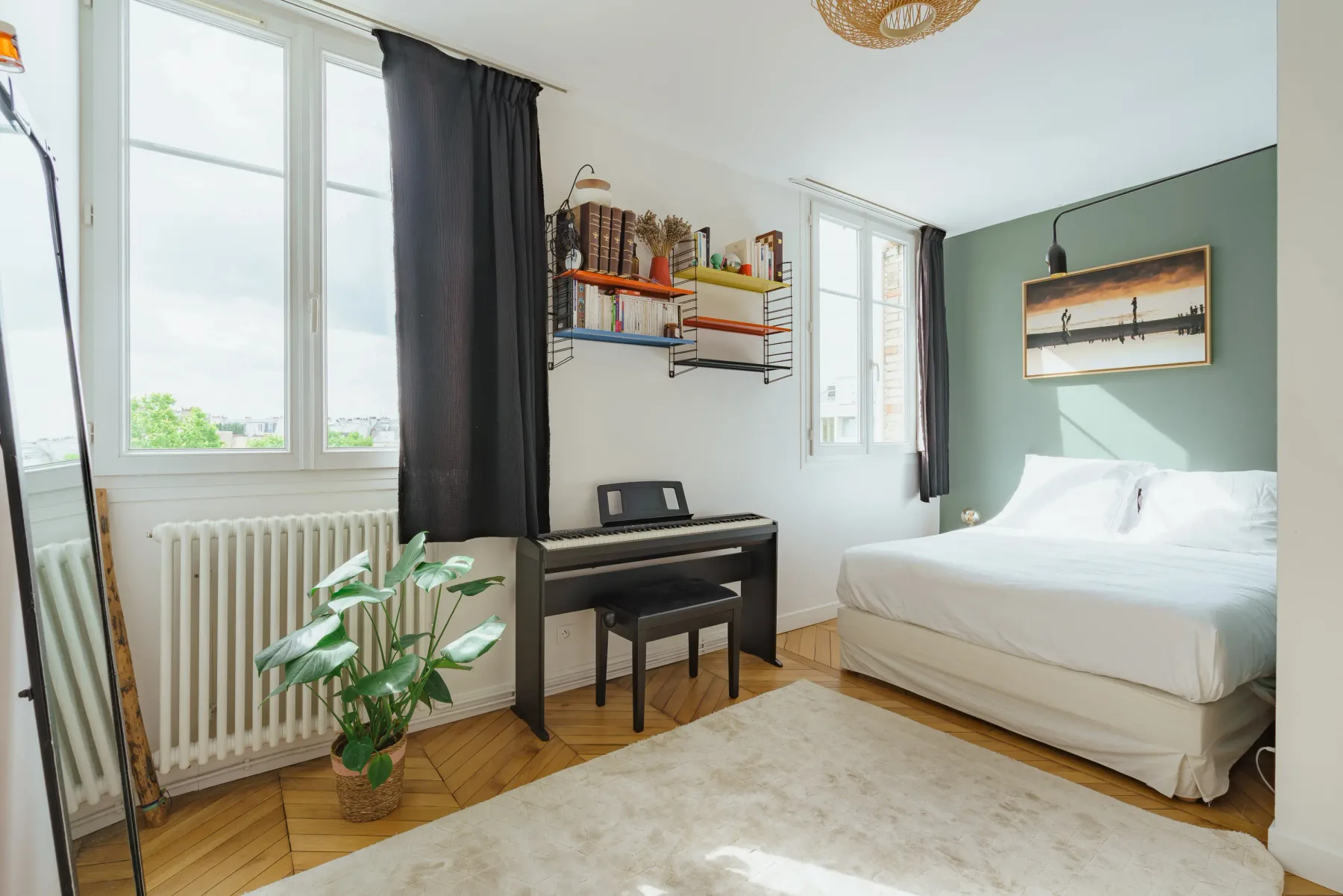 A bright bedroom with a bed, desk, and wall-mounted shelves.