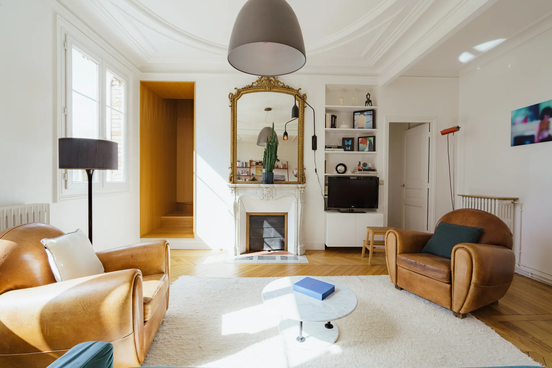 A bright living room with seating arranged around a fireplace and coffee table.