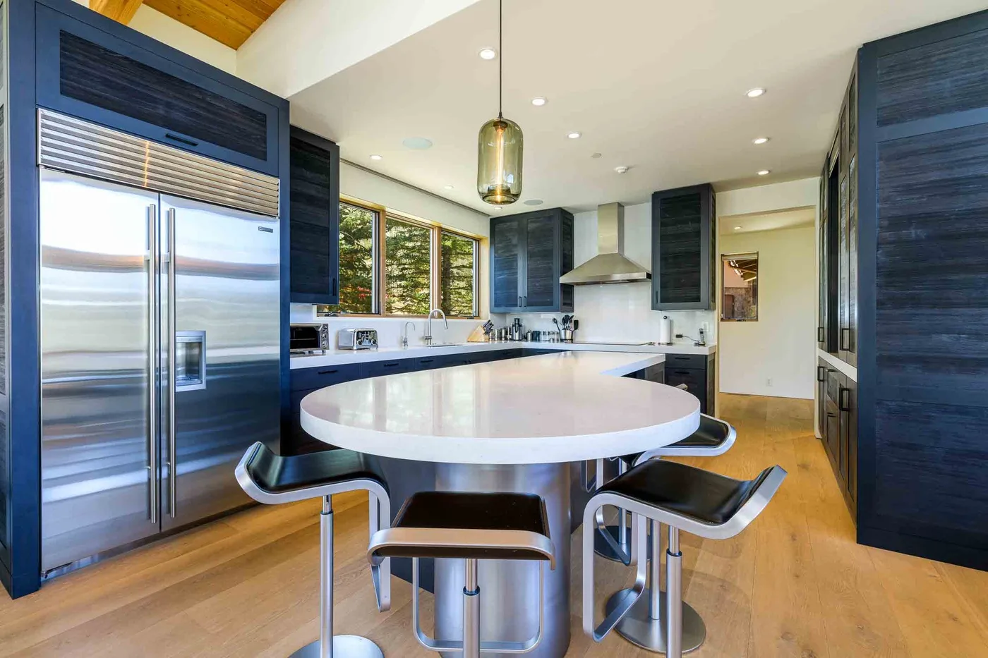 Una cocina moderna con gabinetes oscuros, electrodomésticos de acero inoxidable y una isla grande.