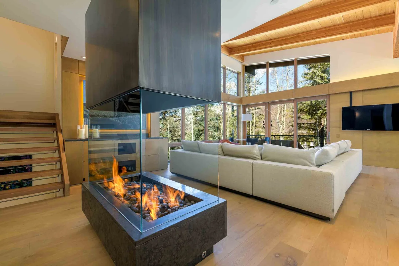 Una sala luminosa con una chimenea de vidrio y asientos.