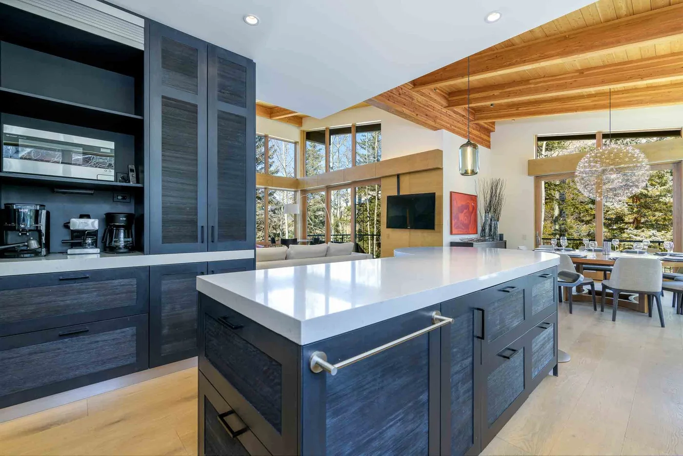 Una cocina moderna con una isla grande se abre a un comedor.