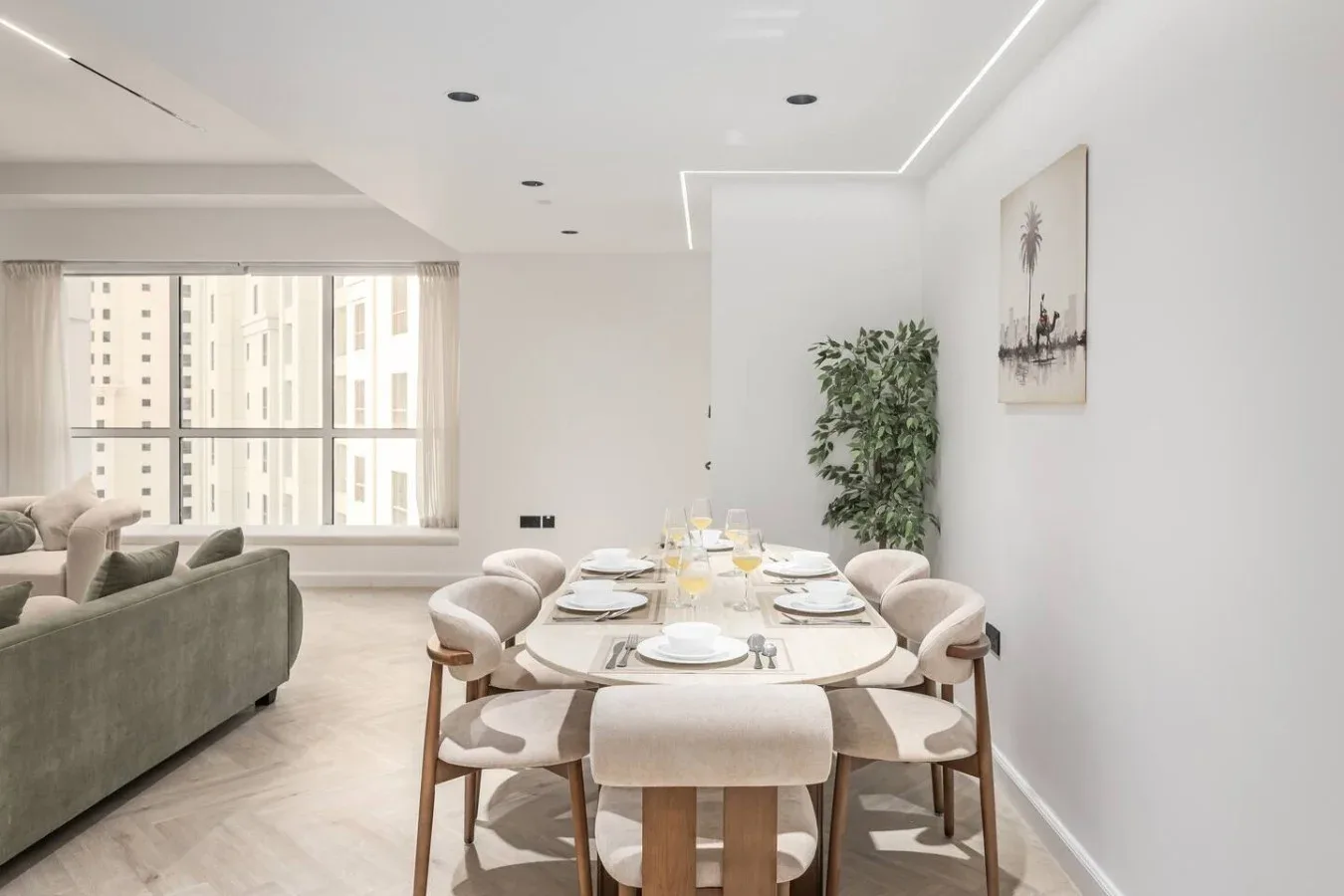 Comedor con mesa y sillas junto a una sala de estar luminosa.