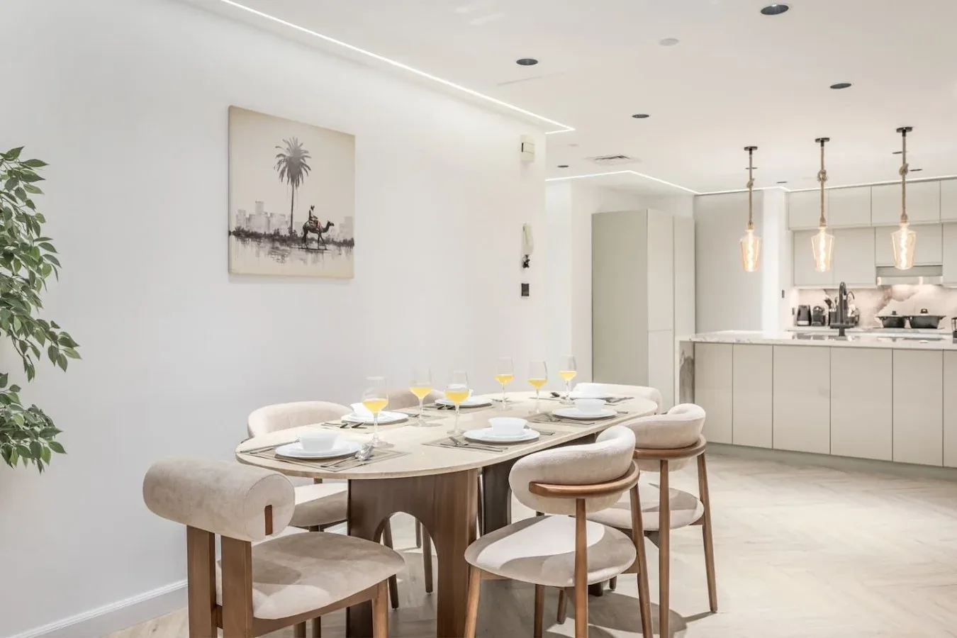 Un comedor luminoso con la mesa puesta junto a una cocina moderna.