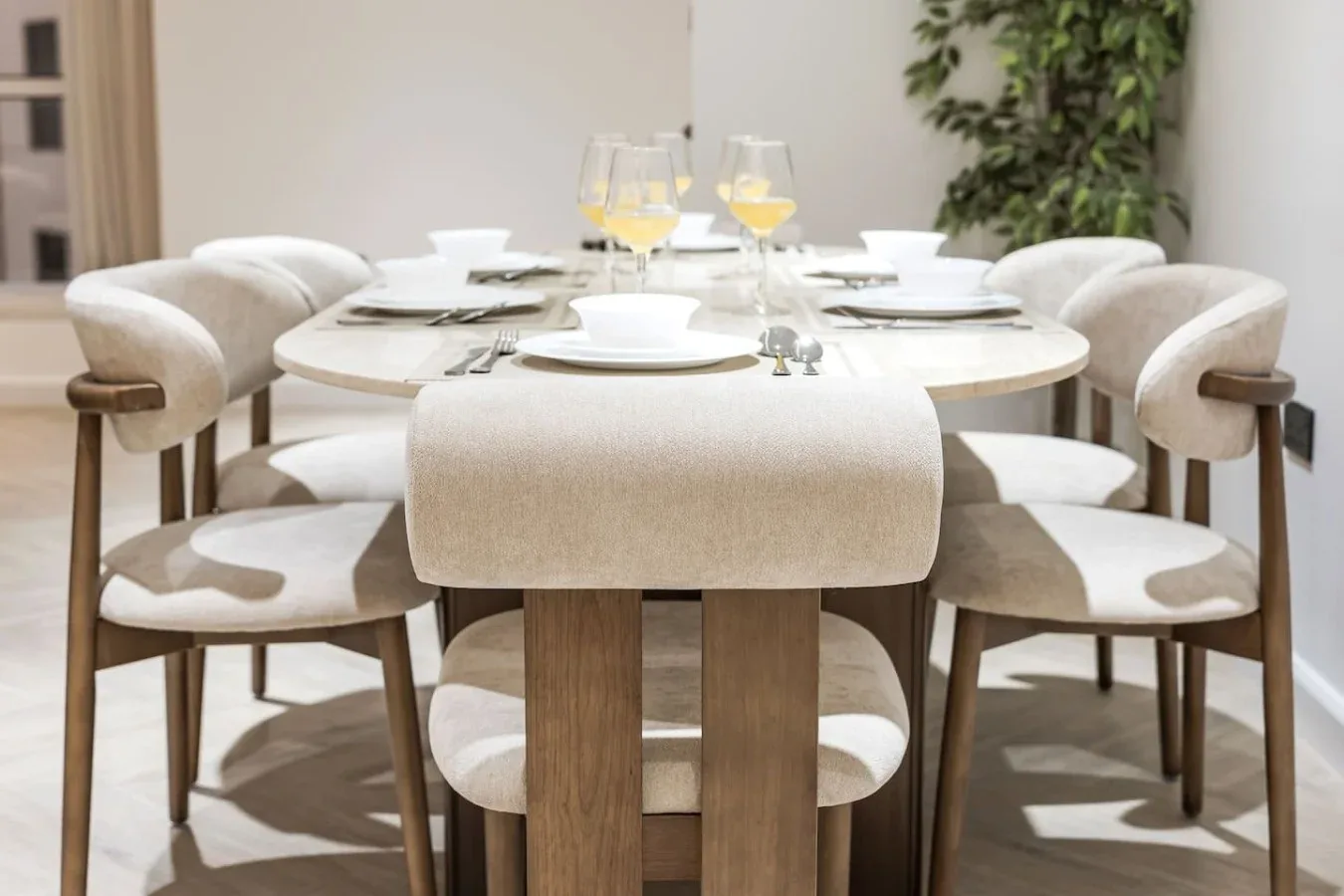 Un comedor con una mesa puesta y asientos tapizados.