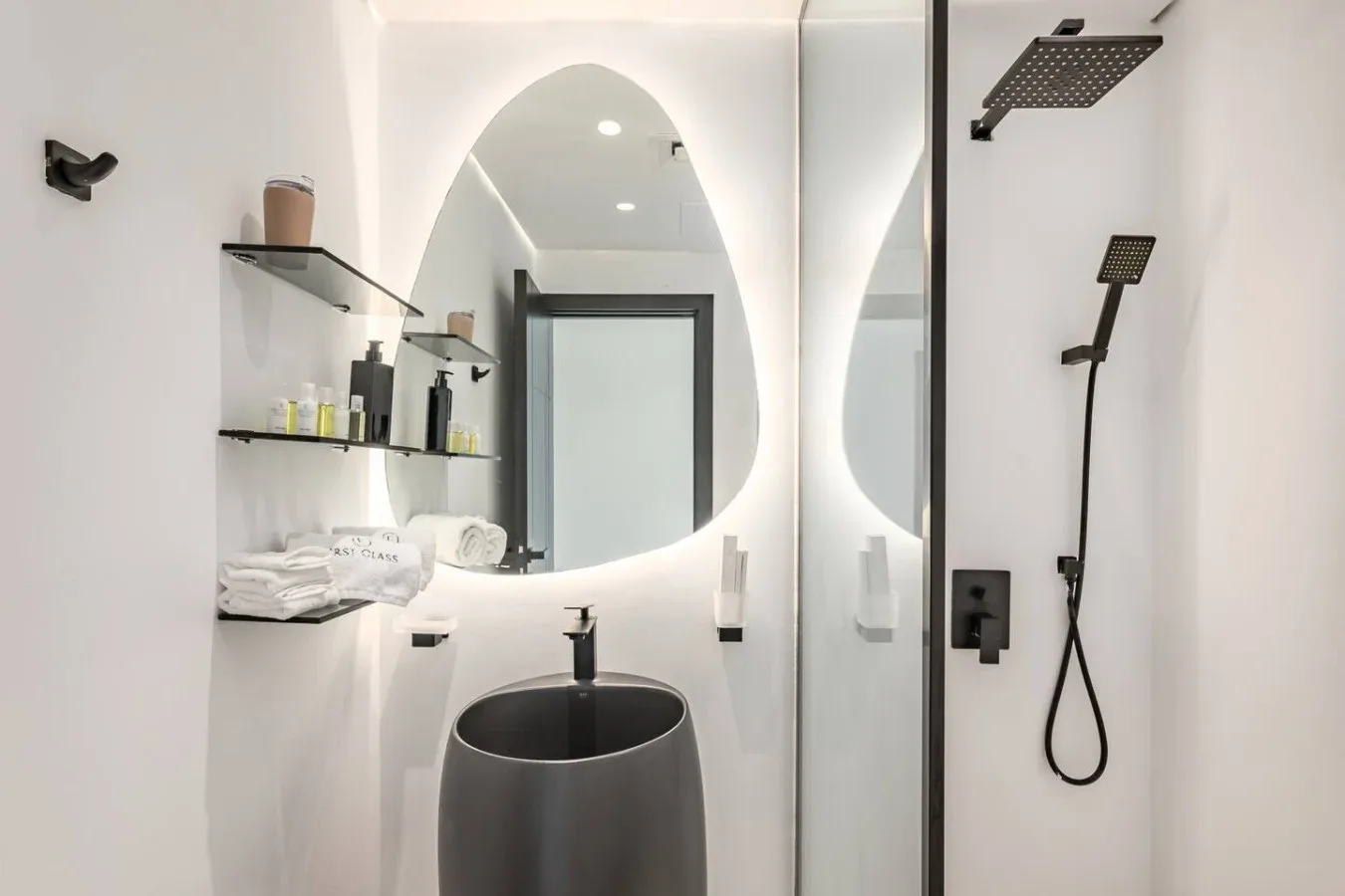 Un baño moderno con lavabo de sobremesa, espejo y ducha.