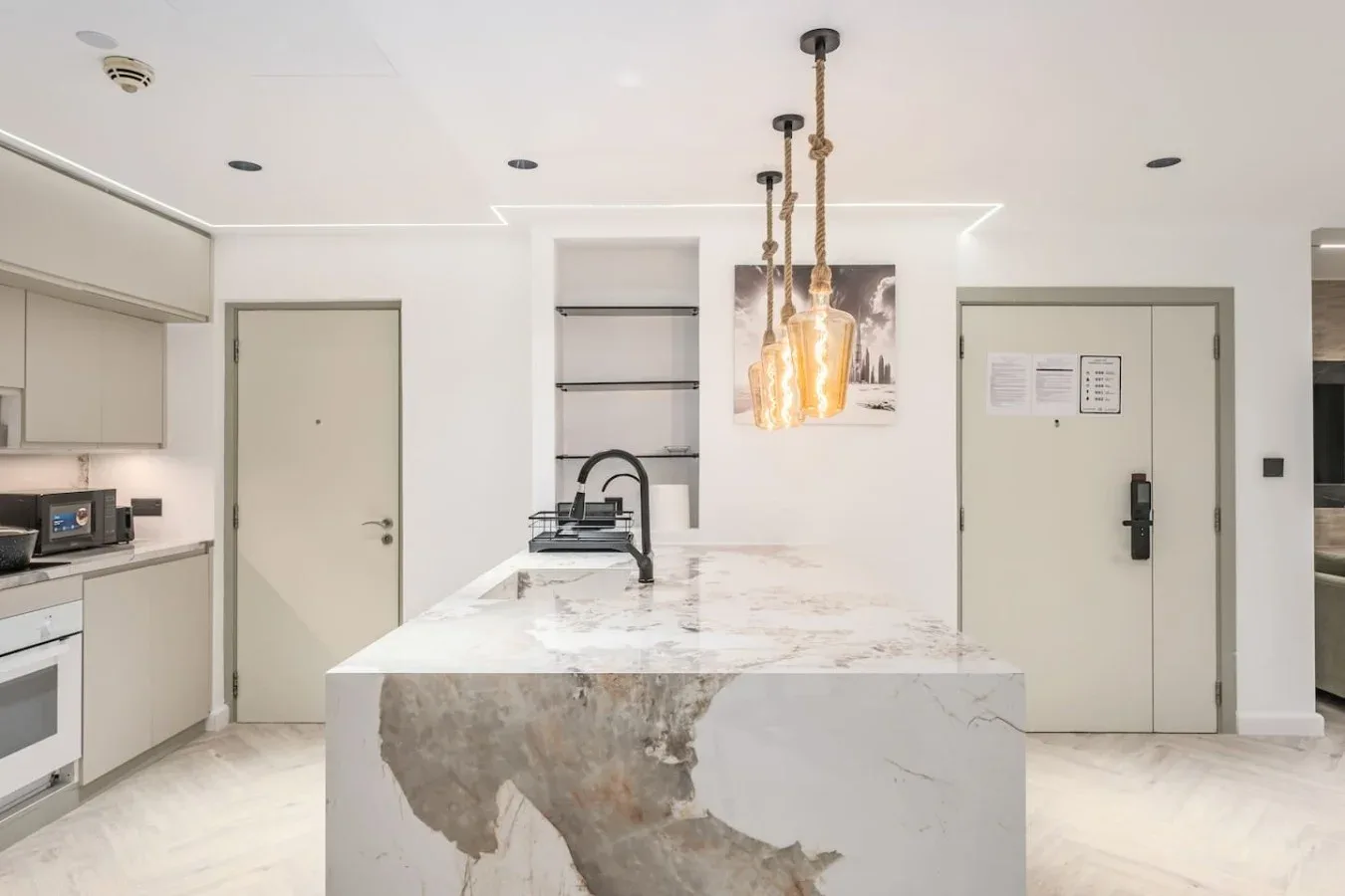 Una cocina moderna con una gran isla de piedra y luces colgantes.