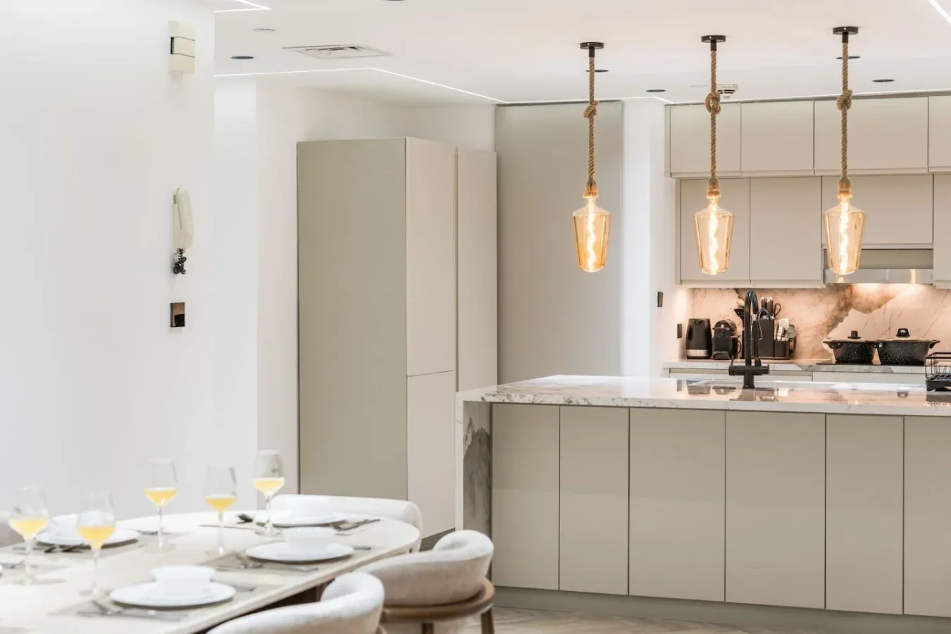 Una cocina luminosa con una mesa de comedor junto a la isla.