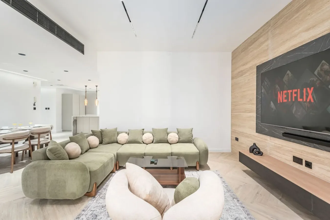 Una sala luminosa con asientos seccionales y un televisor en la pared.