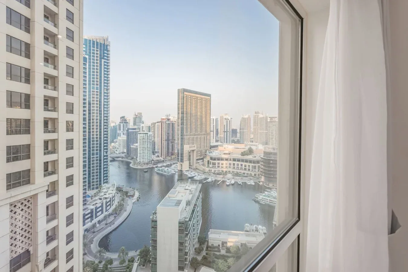 Se ven un horizonte urbano y un canal a través de una ventana grande.