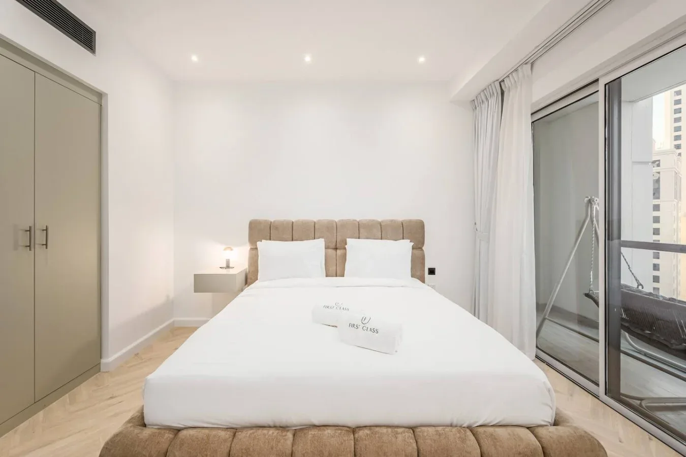 Un dormitorio con una cama grande, una mesita de noche y puertas corredizas de vidrio.