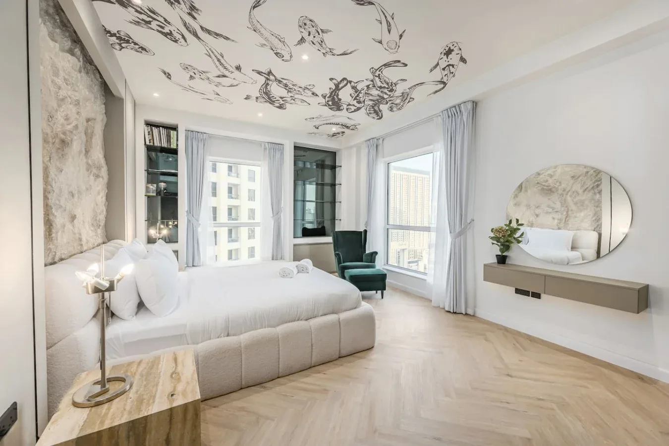 Un dormitorio luminoso con una cama grande, ventanas altas y un techo decorado.