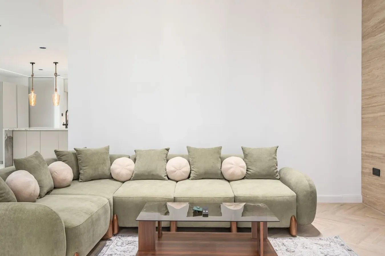 Una sala de estar con sofá seccional, cojines y una mesa de centro baja.