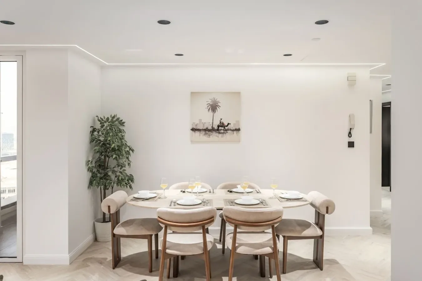 Un comedor luminoso con una mesa larga y asientos tapizados.