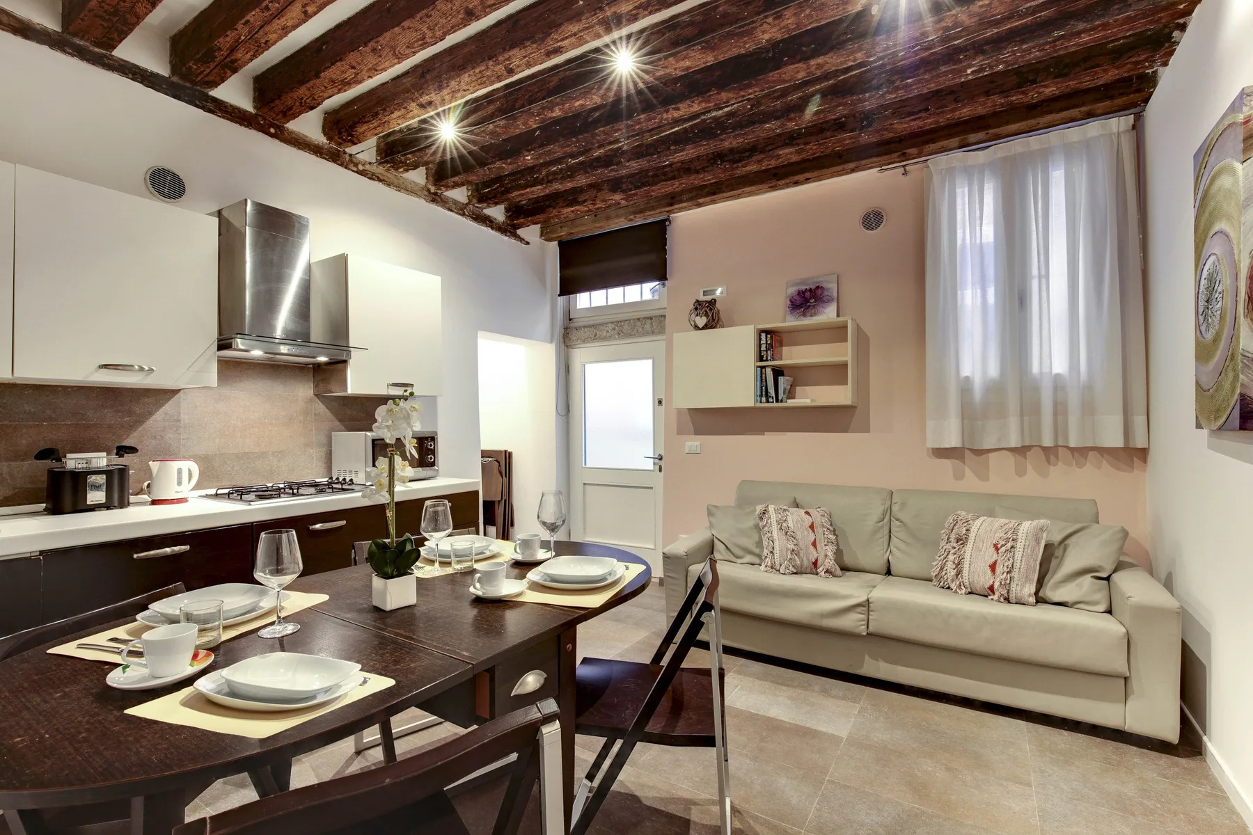 A combined living and dining area with a set table and seating.