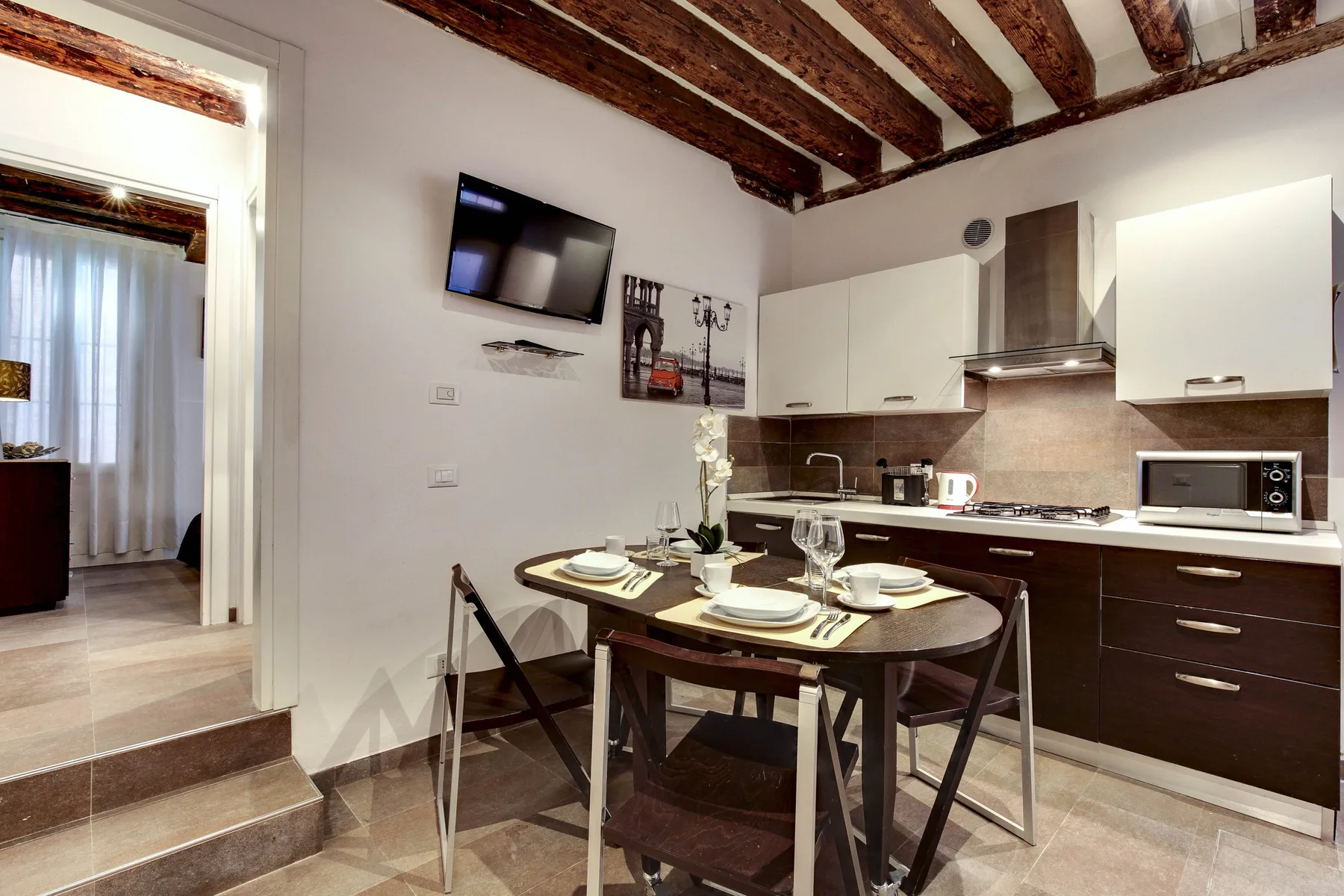 A kitchen and dining area with a table set for a meal.