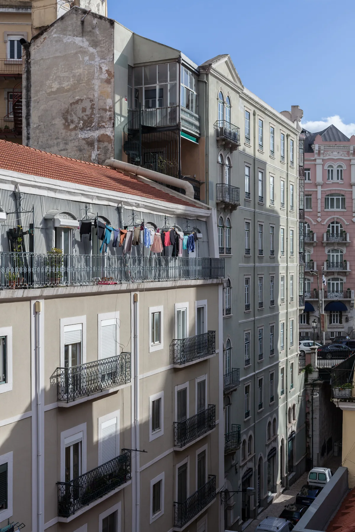 Una calle urbana bordeada de edificios altos con balcones.