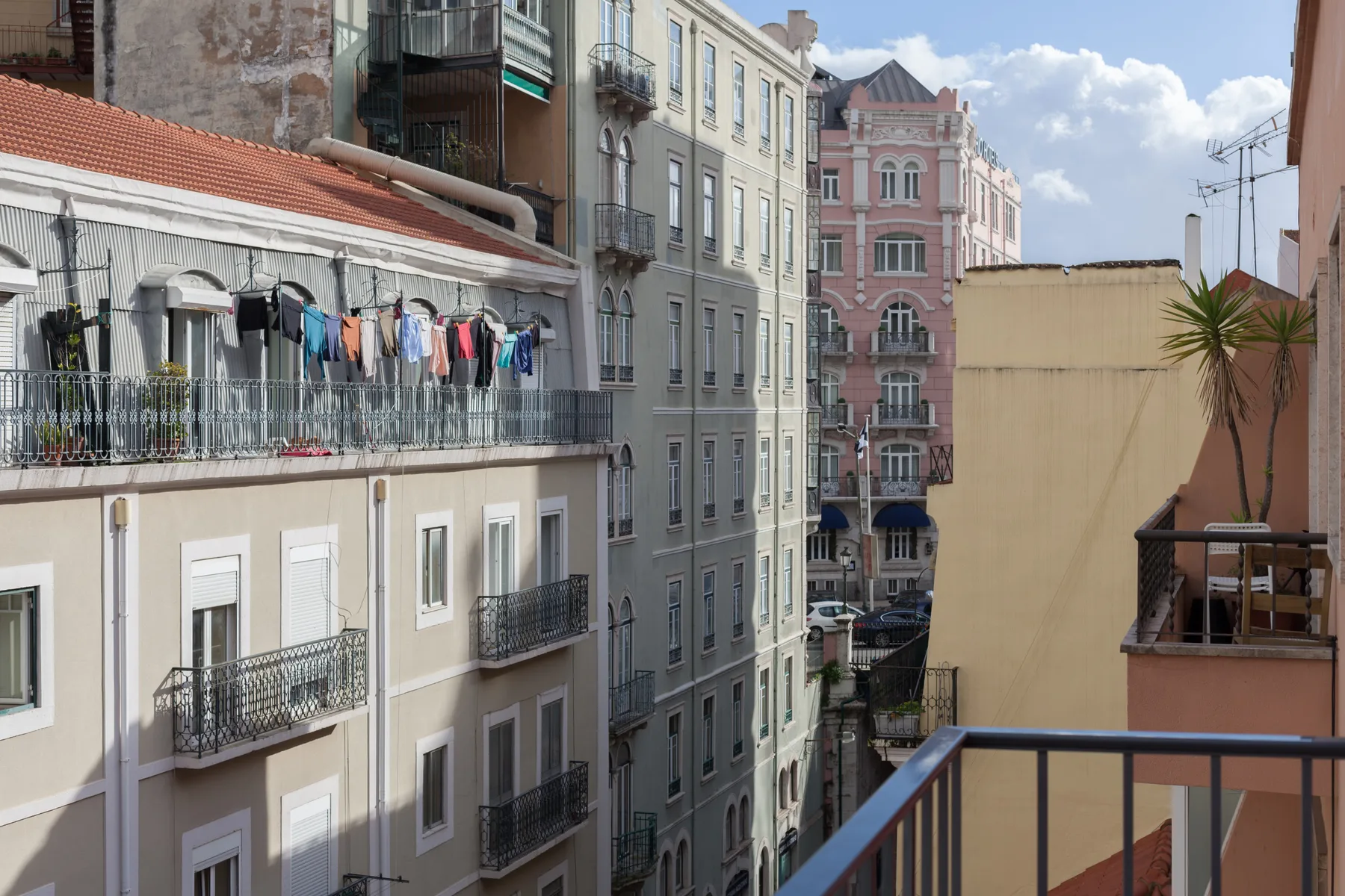 Vista de edificios de Lisboa desde un balcón, con ropa tendida afuera.