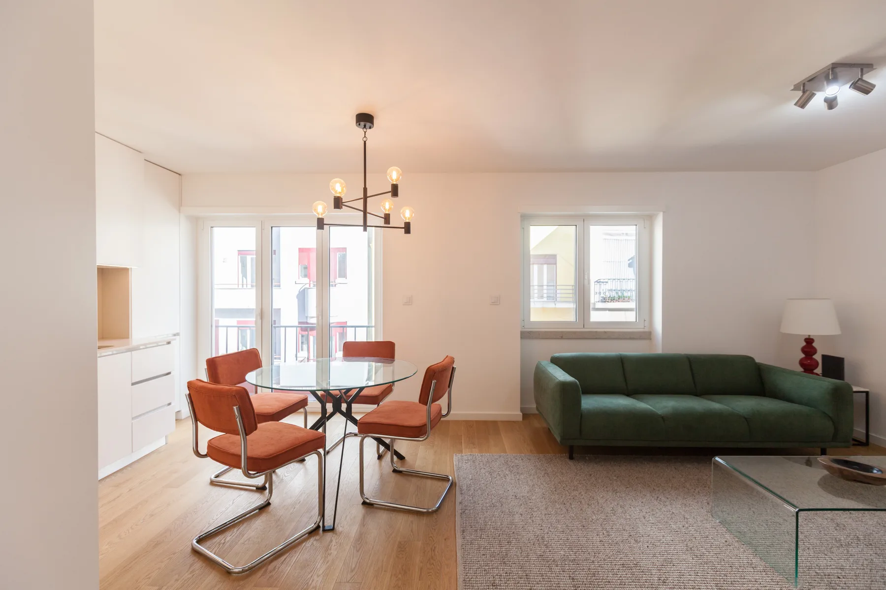Una luminosa sala de estar y comedor con asientos junto a grandes ventanas.