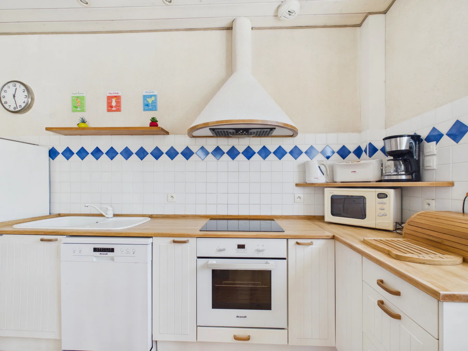 A bright kitchen with a countertop, built-in oven, and small appliances.
