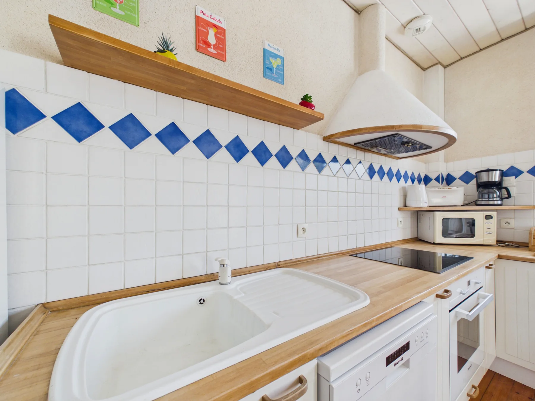 A bright kitchen with a sink, countertop, and cooking appliances.