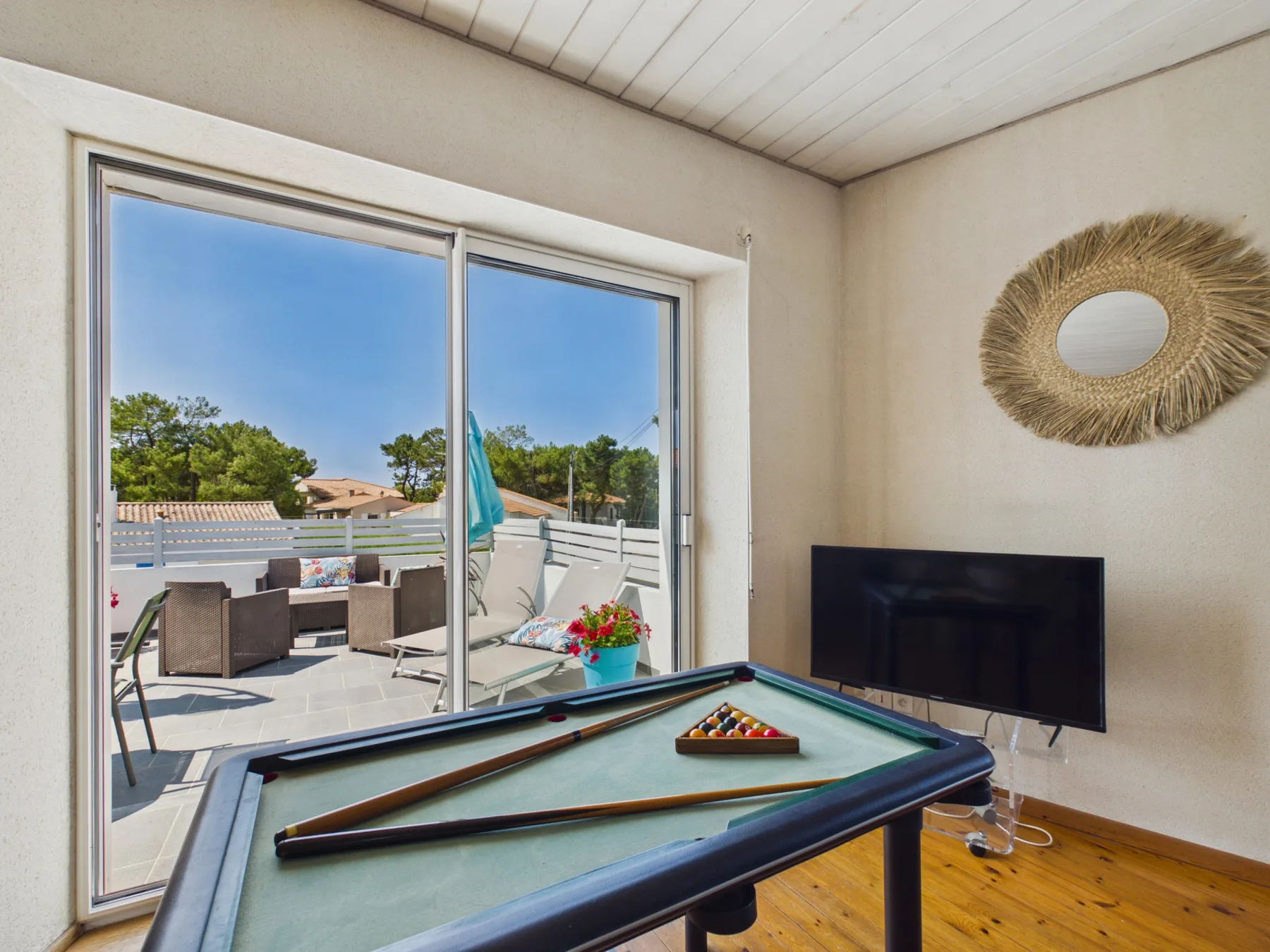 A game room with a pool table and sliding glass doors opening onto a patio.