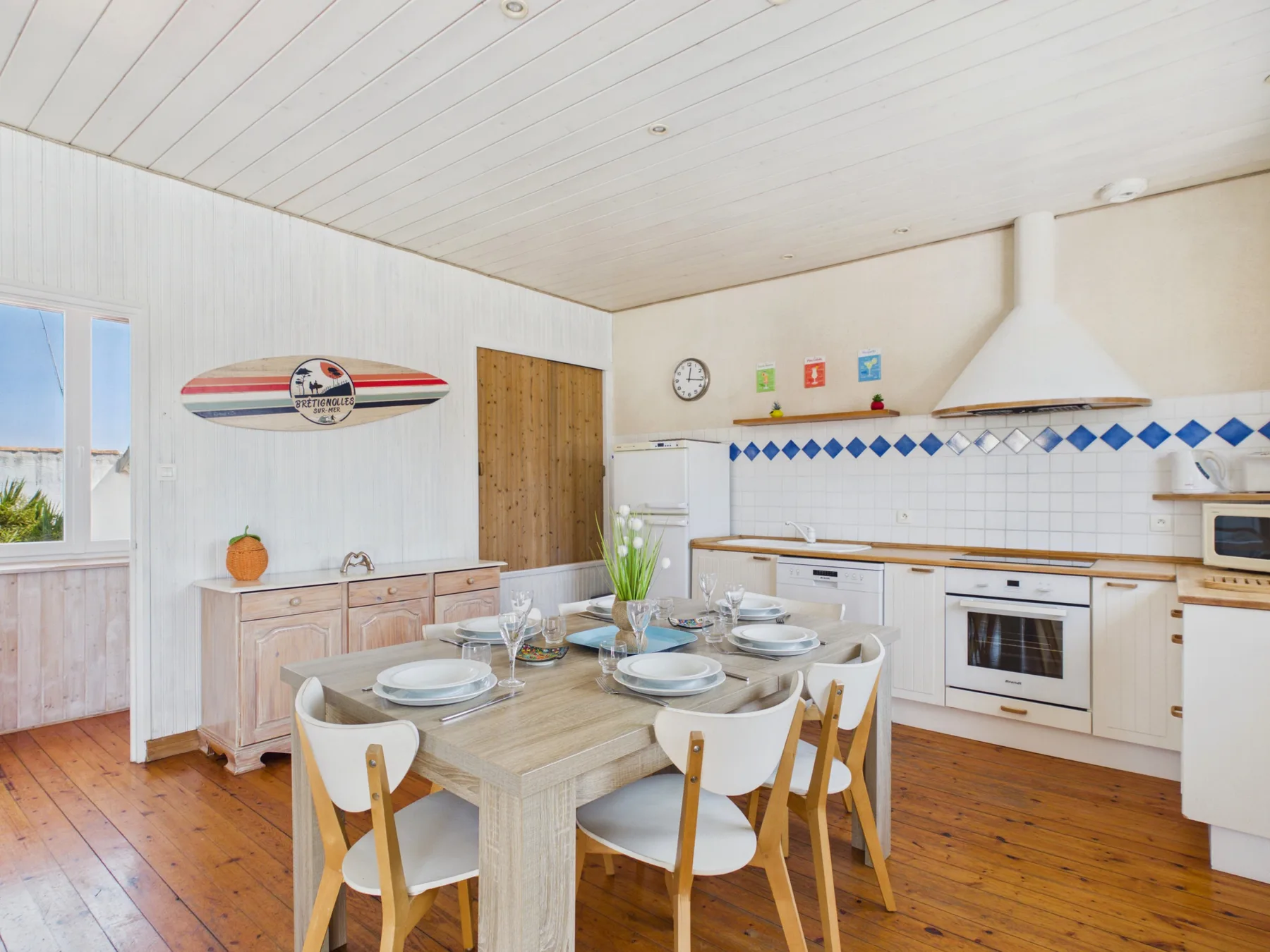 A bright kitchen and dining area with a table set for a meal.