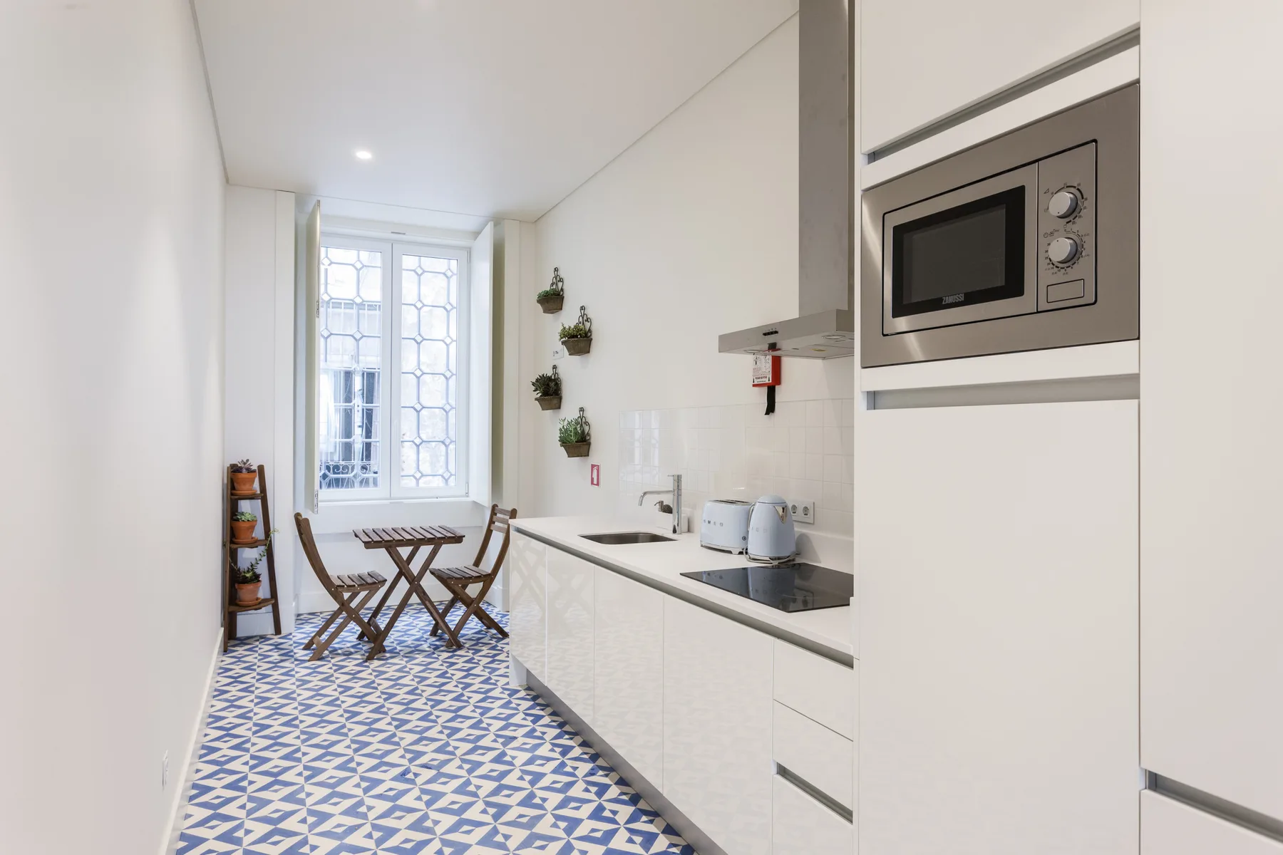 Una cocina luminosa con una mesa de comedor junto a una ventana grande.