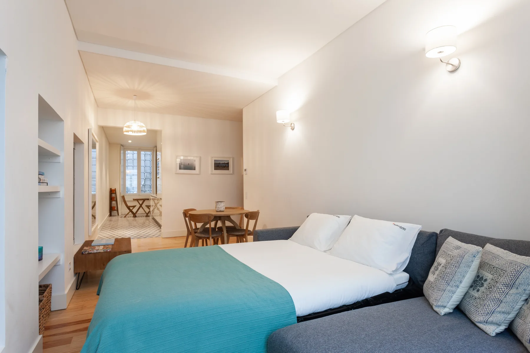A bedroom with a bed, seating, and a small dining area.