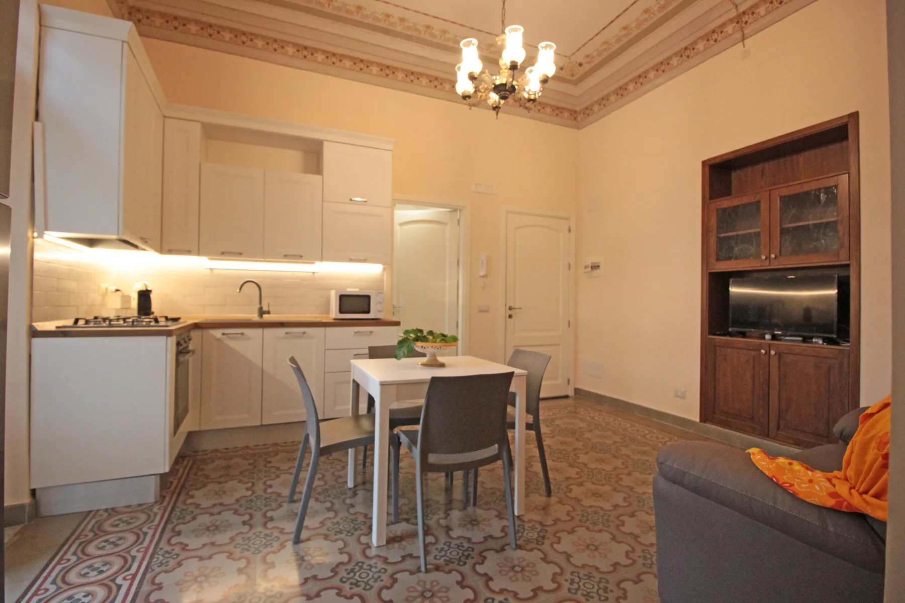 A dining area and kitchen with a table, seating, and built-in cabinetry.