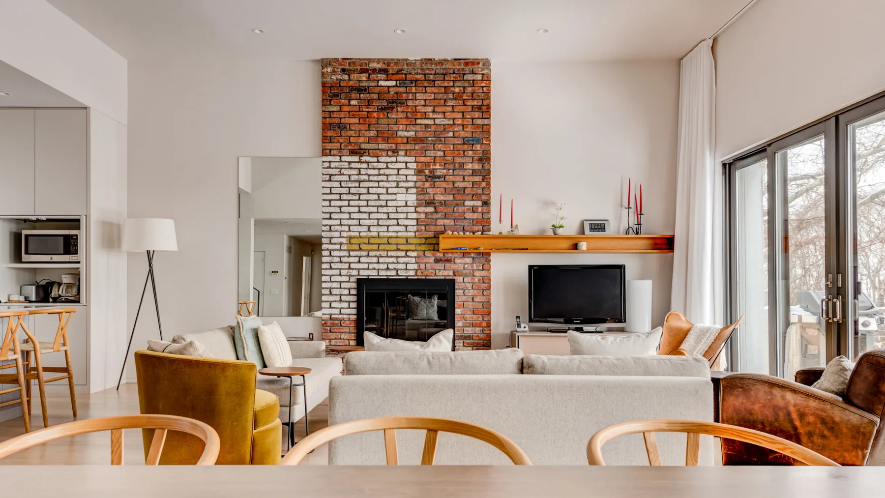 A bright living room with a fireplace, television, and seating.