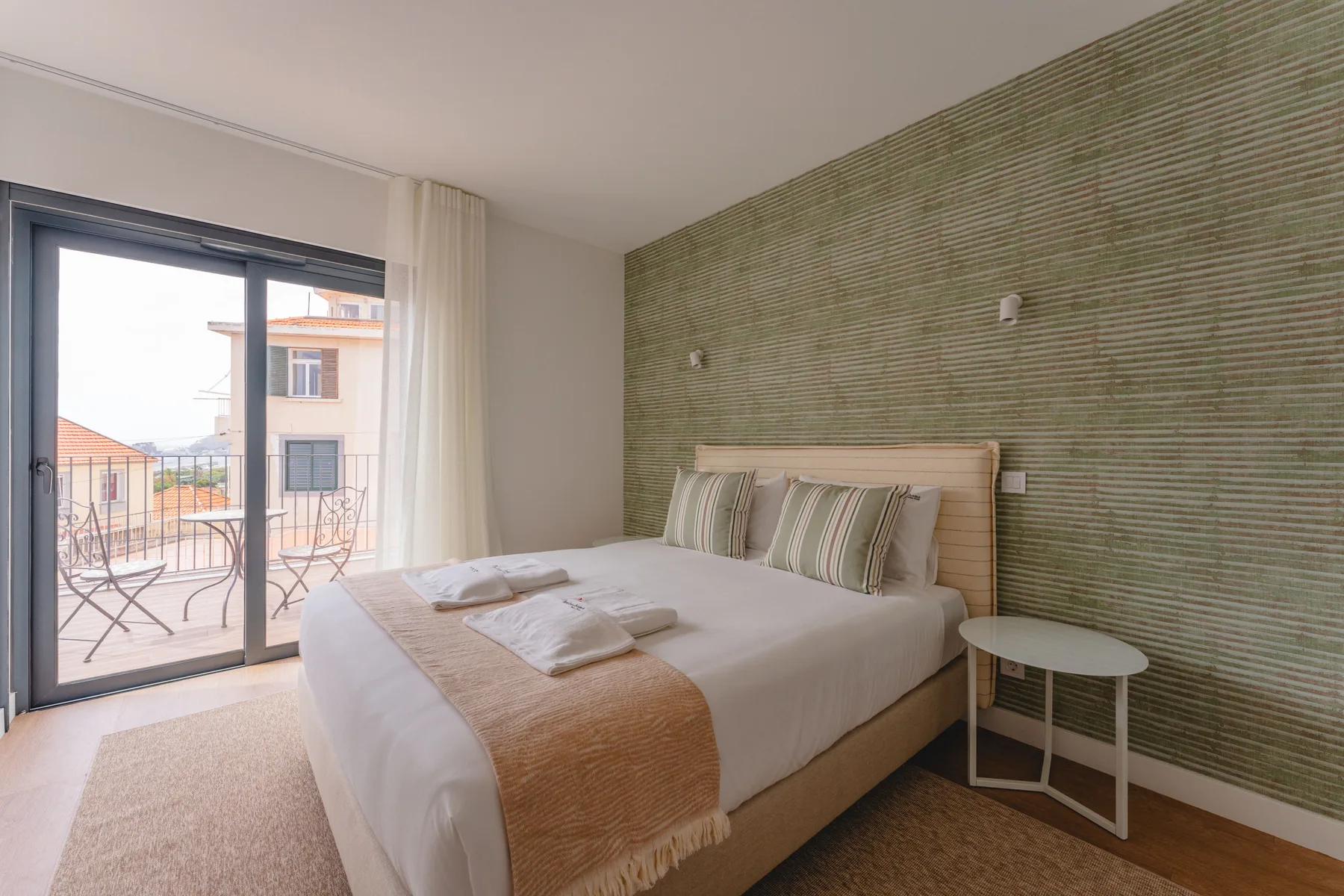 Un dormitorio con cama doble y puertas de cristal que dan a un balcón.