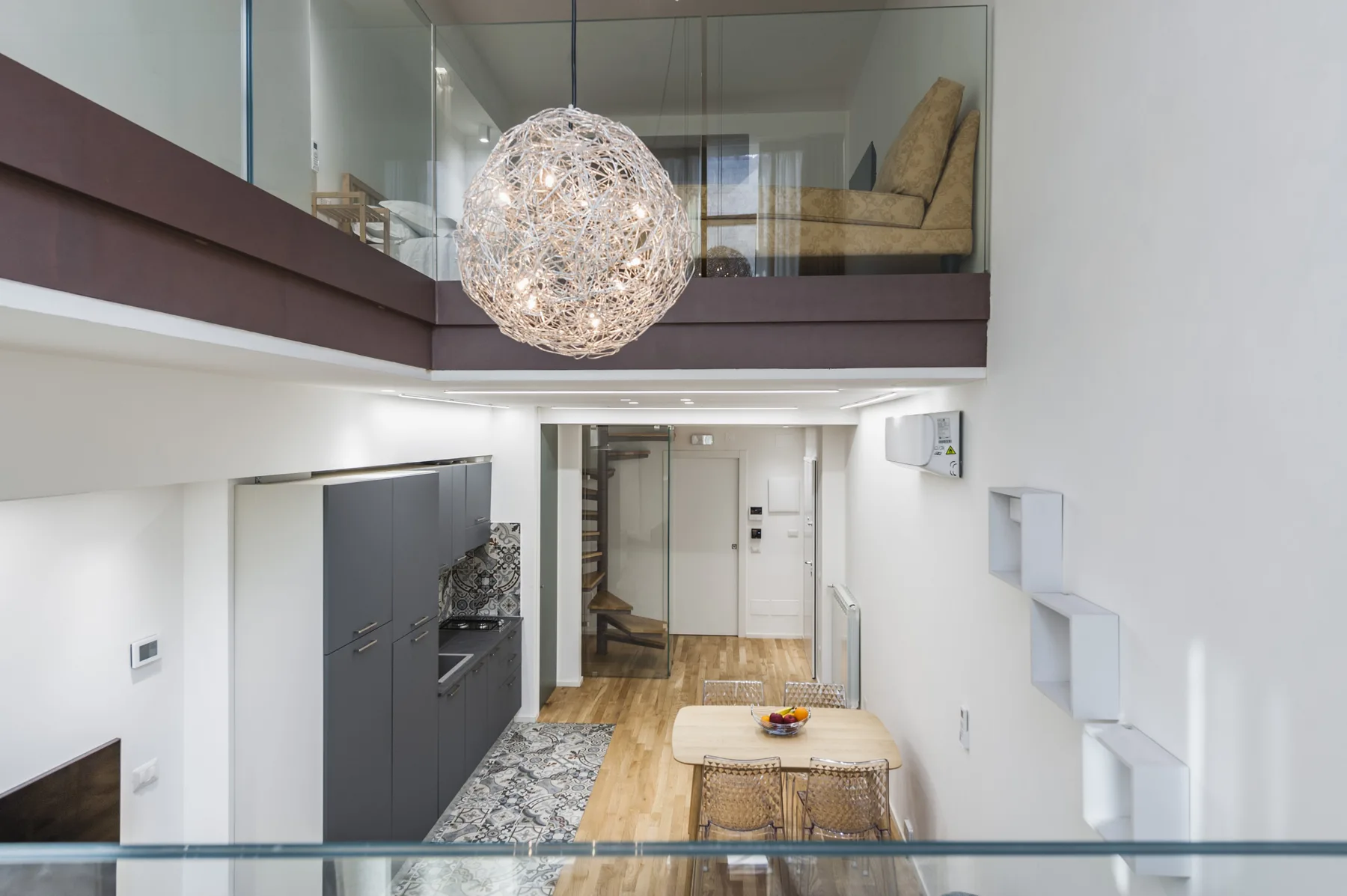 Una sala diáfana moderna con una mesa de comedor bajo una zona elevada para sentarse.